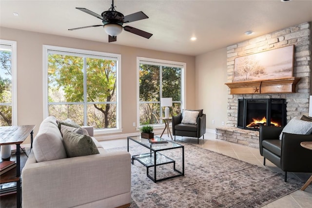 living room with plenty of natural light, ceiling fan, light tile patterned flooring, and a fireplace