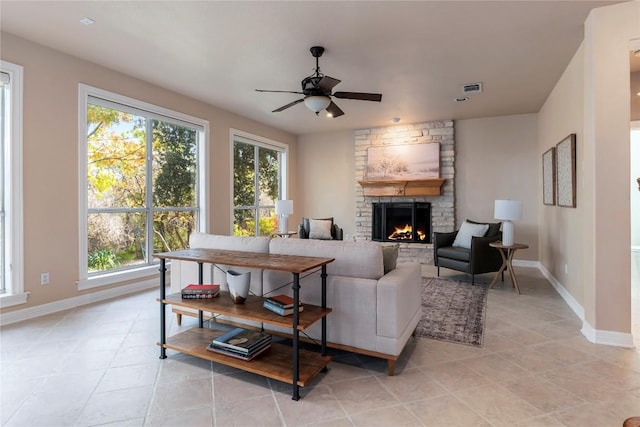 living room with a fireplace, ceiling fan, and light tile patterned flooring