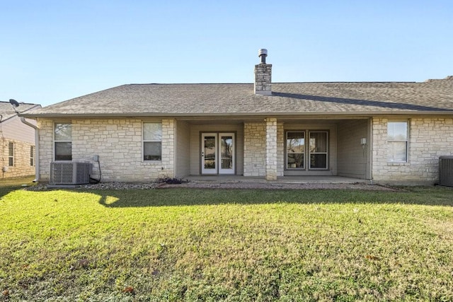 back of property featuring a lawn and central AC