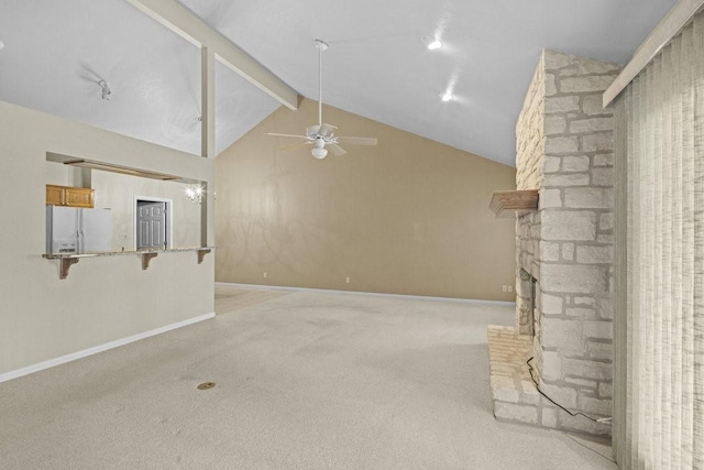 unfurnished living room featuring ceiling fan, a stone fireplace, beamed ceiling, high vaulted ceiling, and light carpet