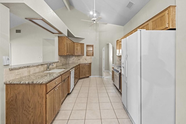 kitchen featuring white appliances, sink, light stone countertops, tasteful backsplash, and light tile patterned flooring