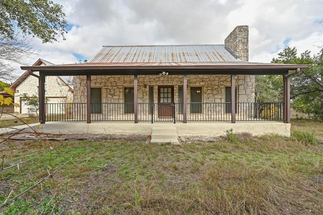 13000 Grubstake Gulch St, Bee Cave, TX 78738 - rear view of house with stone siding, a chimney, a porch, and metal roof