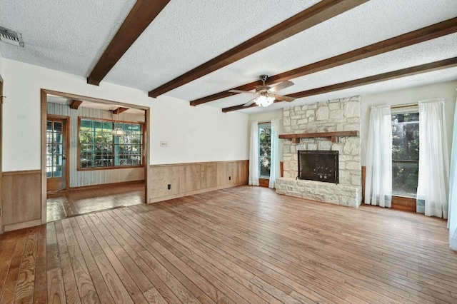 13000 Grubstake Gulch St, Bee Cave, TX 78738 - unfurnished living room featuring a wainscoted wall, a textured ceiling, hardwood / wood-style floors, beam ceiling, and ceiling fan