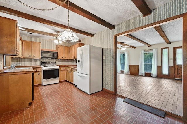 13000 Grubstake Gulch St, Bee Cave, TX 78738 - kitchen featuring white appliances, wallpapered walls, a ceiling fan, baseboards, and a sink
