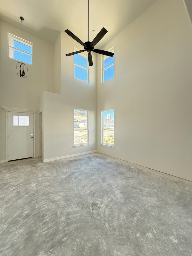 unfurnished living room with ceiling fan and high vaulted ceiling