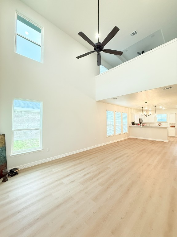 247 Fawn Ridge Dr, Copperas Cove, TX 76522 - unfurnished living room with a high ceiling, light wood finished floors, plenty of natural light, and baseboards