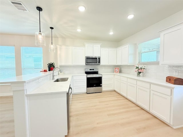247 Fawn Ridge Dr, Copperas Cove, TX 76522 - kitchen featuring stainless steel appliances, a sink, a peninsula, tasteful backsplash, and white cabinetry