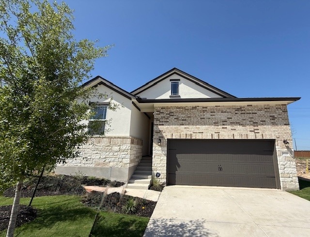 1020 Stonehill Dr, Georgetown, TX 78633 - view of front facade featuring stone siding, an attached garage, stucco siding, driveway, and brick siding