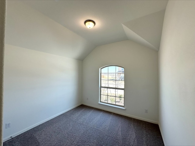 additional living space with lofted ceiling, baseboards, and dark colored carpet