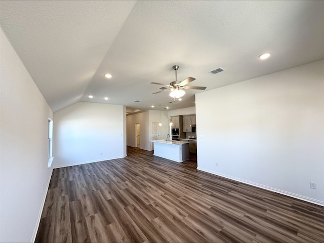 unfurnished living room featuring a ceiling fan, dark wood-style flooring, visible vents, and baseboards