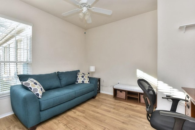 office space with baseboards, a wealth of natural light, light wood-style flooring, and a ceiling fan