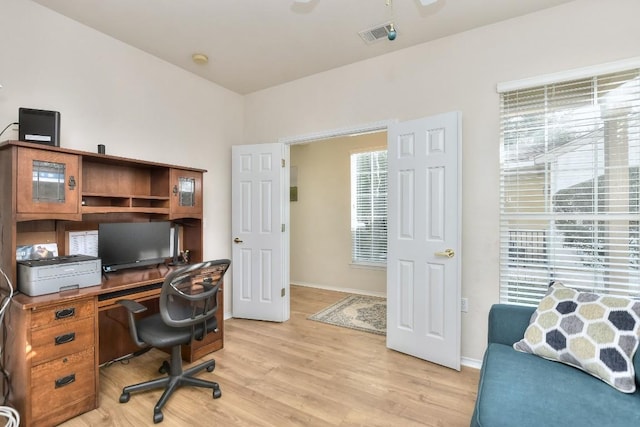 office featuring light wood finished floors, visible vents, and baseboards