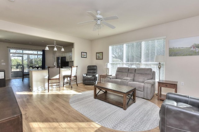 living area with light wood-style flooring and ceiling fan