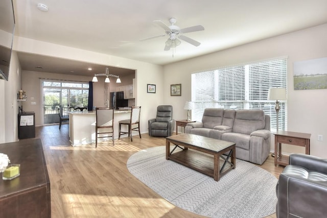 living area with a ceiling fan and light wood finished floors