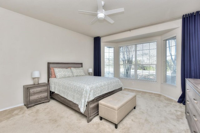 bedroom featuring light carpet, ceiling fan, and baseboards