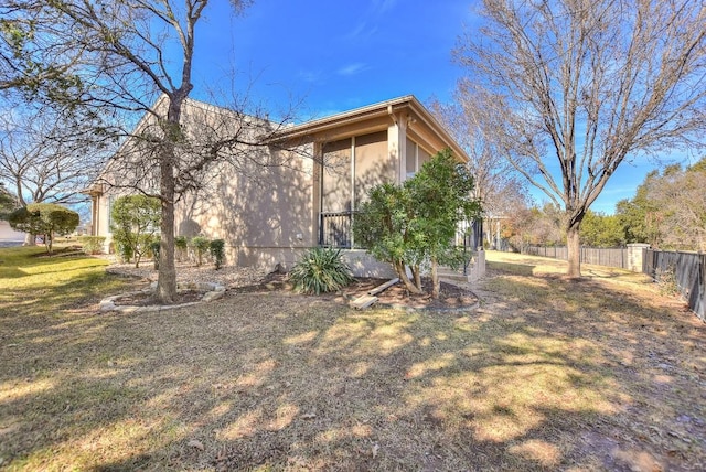 view of side of home featuring a yard and fence