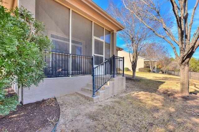 view of property exterior featuring a sunroom and stucco siding