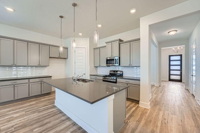 144 Adelton Blvd, Bastrop, TX 78602 - kitchen with stainless steel appliances, gray cabinets, a sink, dark countertops, and recessed lighting