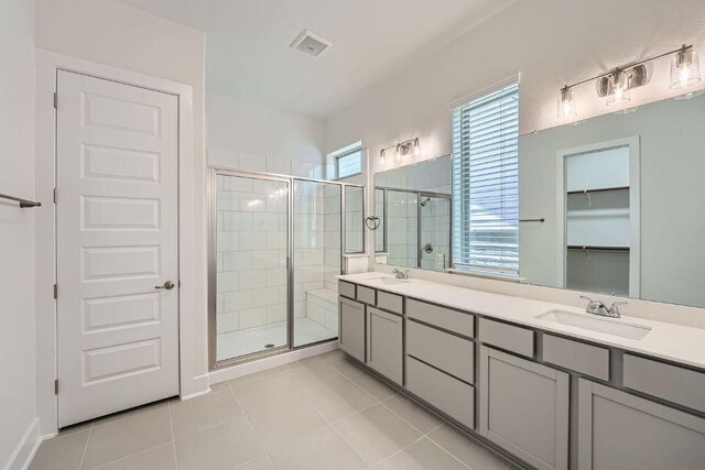 144 Adelton Blvd, Bastrop, TX 78602 - bathroom featuring a stall shower, tile patterned flooring, double vanity, and a spacious closet