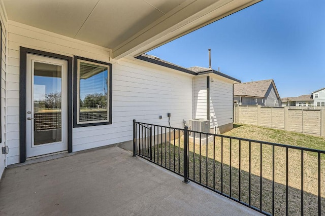view of patio featuring central AC unit and fence