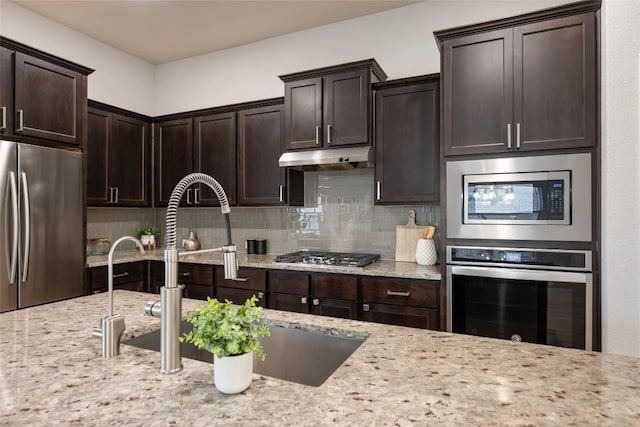 kitchen featuring backsplash, sink, stainless steel appliances, and dark brown cabinets