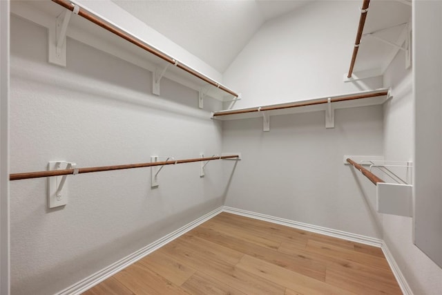 spacious closet featuring hardwood / wood-style floors and lofted ceiling