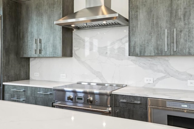 kitchen featuring wall oven, tasteful backsplash, stainless steel stove, and wall chimney range hood