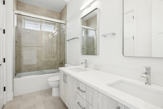 full bathroom with vanity, enclosed tub / shower combo, and toilet