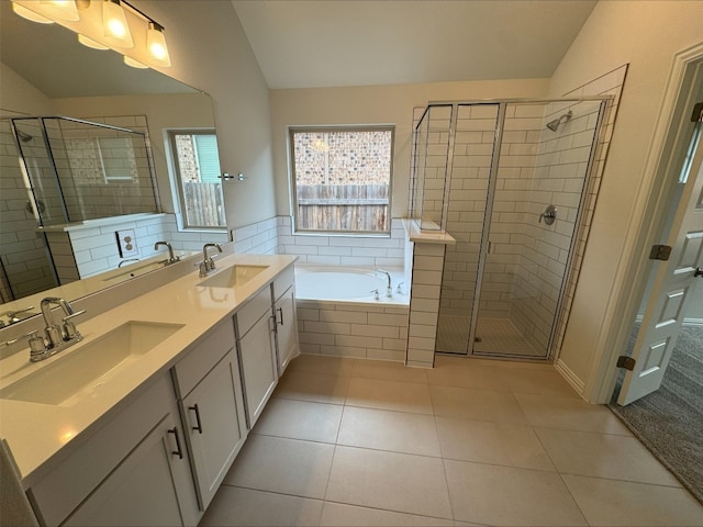 bathroom featuring lofted ceiling, vanity, tile patterned flooring, and shower with separate bathtub