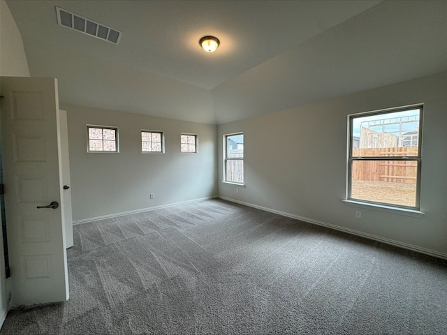 empty room featuring vaulted ceiling and carpet