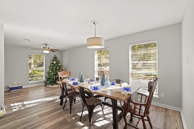 dining room with plenty of natural light, wood finished floors, visible vents, and baseboards