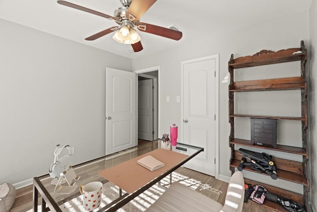 office space with ceiling fan, baseboards, and wood finished floors