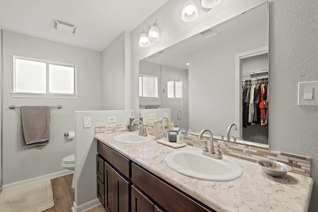 full bathroom with double vanity, visible vents, a shower stall, and a sink