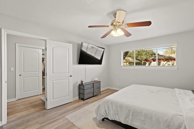 bedroom featuring light wood-type flooring, baseboards, and a ceiling fan