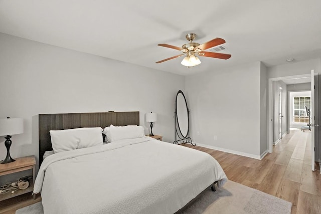 bedroom featuring a ceiling fan, visible vents, baseboards, and light wood-type flooring