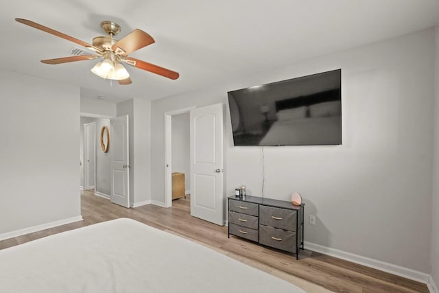 unfurnished bedroom with ceiling fan, baseboards, and wood finished floors