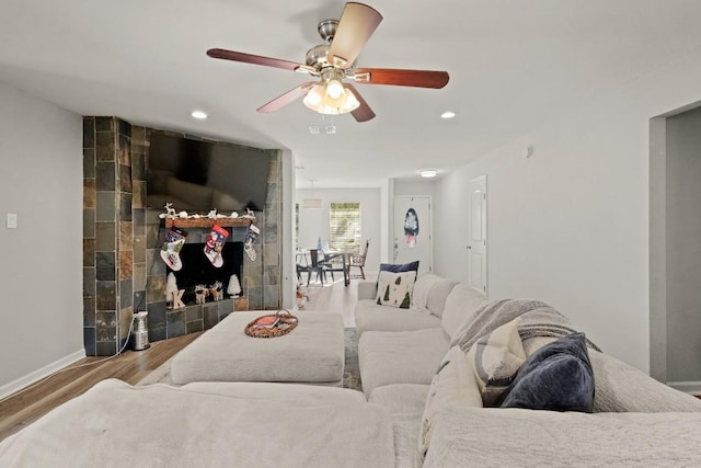 living room featuring wood finished floors, recessed lighting, baseboards, ceiling fan, and a tile fireplace