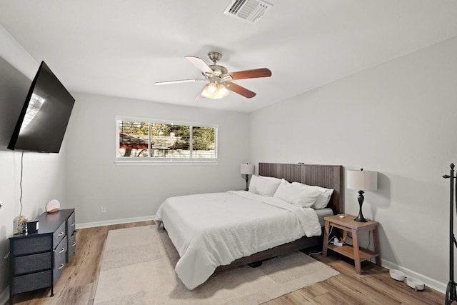 bedroom with visible vents, light wood-style flooring, baseboards, and ceiling fan