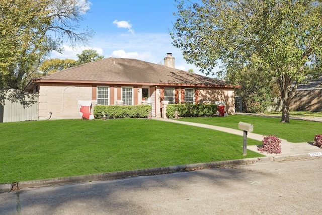 ranch-style house with a front lawn, brick siding, and a chimney