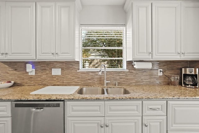 kitchen with tasteful backsplash, white cabinets, and stainless steel dishwasher