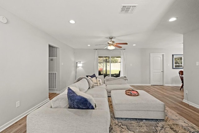 living room with visible vents, recessed lighting, baseboards, and wood finished floors