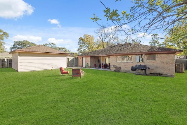 rear view of property with cooling unit, a lawn, and fence