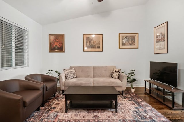 living room with ceiling fan, dark hardwood / wood-style flooring, and vaulted ceiling