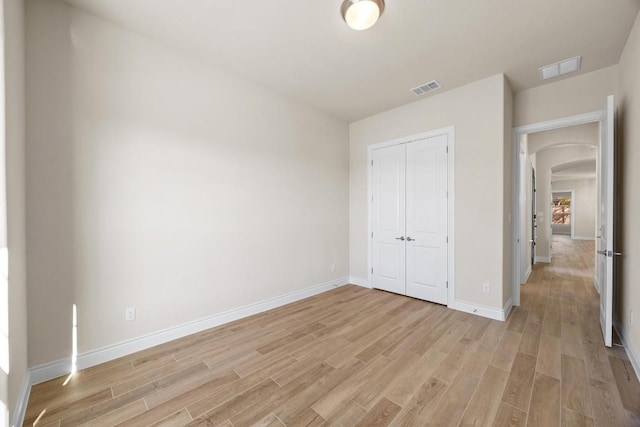 unfurnished bedroom with light wood-type flooring and a closet