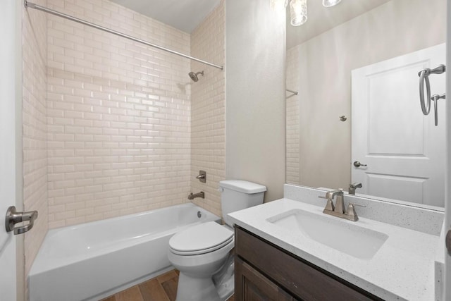 full bathroom featuring vanity, tiled shower / bath combo, wood-type flooring, and toilet