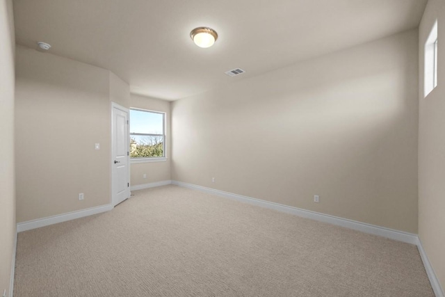 spare room featuring light carpet