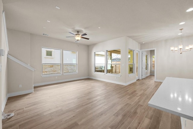 225 Skyflower Dr, Georgetown, TX 78628 - unfurnished living room featuring light wood finished floors, a chandelier, a ceiling fan, and recessed lighting