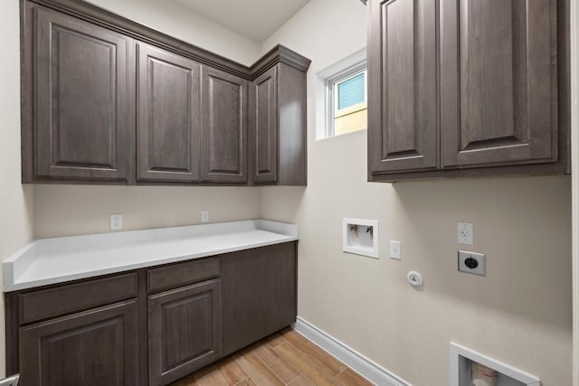 225 Skyflower Dr, Georgetown, TX 78628 - laundry room featuring cabinet space, hookup for an electric dryer, hookup for a gas dryer, baseboards, and light wood finished floors