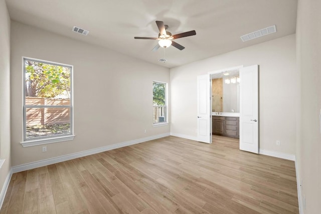 225 Skyflower Dr, Georgetown, TX 78628 - unfurnished bedroom featuring light wood-style flooring, baseboards, ensuite bathroom, and a ceiling fan