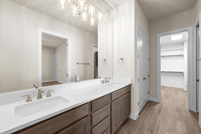 225 Skyflower Dr, Georgetown, TX 78628 - full bathroom with double vanity, wood finished floors, a spacious closet, and baseboards